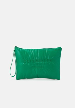 Grøn, polstret clutch-pung med præget "Copenhagen Studios" tekst, lynlås-lukning og aftagelig håndledsrem. Glat, struktureret overflade.