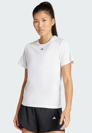 White athletic t-shirt with short sleeves and a round neckline, featuring a small black logo on the chest. Paired with black shorts.