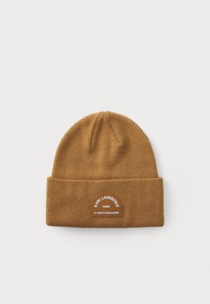 Gorro de lana marrón con un dobladillo, que presenta un parche de cuero redondo grabado con "KARL LAGERFELD PARIS" y detalles de dirección.