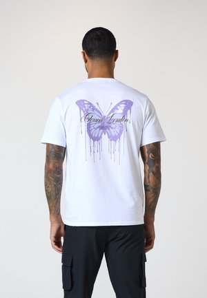 White cotton t-shirt featuring a large purple butterfly graphic on the back, with paint drip details. The front is plain without design.