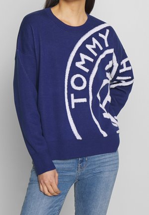 Blauwe gebreide trui met witte "TOMMY" logo, ronde halslijn, relaxte pasvorm en geribbelde manchetten en zoom.