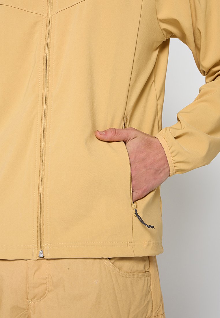 Jasnożółta kurtka zapinana na zamek z stójką, elastycznymi mankietami i bocznymi kieszeniami. Gładki materiał o dopasowanym kroju.