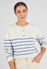 Gestreepte trui in crème met blauwe horizontale strepen, voorzien van een ronde halslijn en een placket met drie knopen. Zachte, gebreide textuur.
