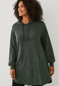Groene fleece hoodie jurk met een ontspannen pasvorm, grote voorzakken, ribbelmanchetten en een trekkoordcapuchon. Zachte textuur en lengte tot halverwege de bovenbenen.