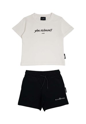 T-shirt bianca corta con testo "John Richmond London" abbinata a pantaloncini neri con coulisse e logo "Richmond" sulla gamba sinistra.