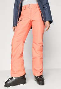 Τα ροζ σκι παντελόνια διαθέτουν μια λείaoδρη, αδιάβροχη επιφάνεια, μια τσέπη με φερμουάρ, δύο κουμπιά κλεισίματος και είναι σχεδιασμένα για χαλαρή εφαρμογή.