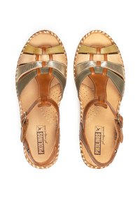 Sandales en cuir marron et doré avec un design tissé, bride de cheville et détails perforés. Texture lisse avec des accents métalliques contrastants.