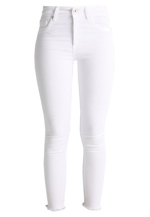Hvite, smale jeans laget av denim. Funksjoner inkluderer høy midje, fem-lommers design og frynset kant ved anklene.