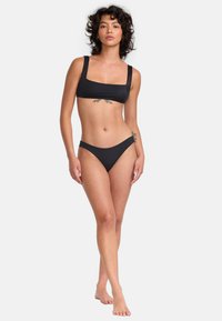 Black bikini set featuring a square-neck top with wide straps and matching low-rise bottom, made of smooth, stretchy fabric.