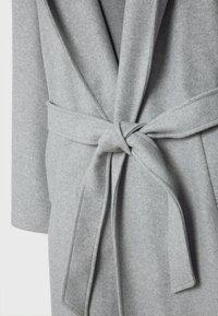 Abrigo de lana gris claro con un cinturón ancho atado en un nudo en la parte delantera, que cuenta con mangas largas y un collar con solapa.