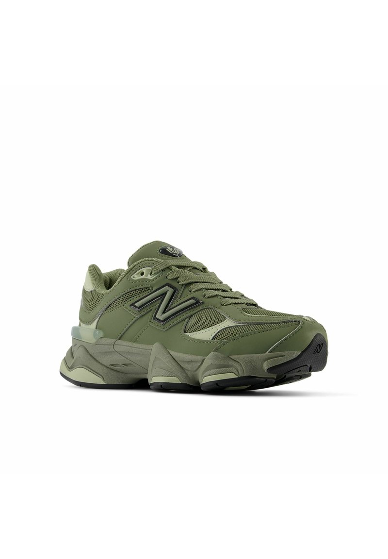 Baskets de course vert olive avec tige en maille et en synthétique, semelle épaisse, logo 'N' proéminent et accents texturés. Présente une pointe arrondie et un système de laçage.