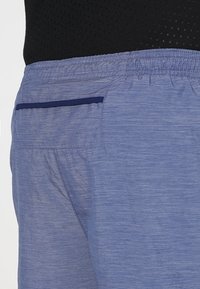 Herrarnas träningsshorts i ljusblått tyg med en texturerad look, elastisk midja och en lappficka med mörkblå kant.