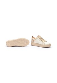 Zapatillas beige con parte superior de cuero liso, puntera redonda, suela de goma elevada y cierre de cordones. Incluye una suela texturizada con marca.