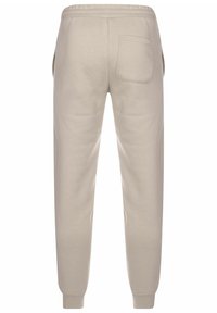 Pantaloni de trening bej din amestec de bumbac, cu croi conic, talie elastică și o singură buză pe spate cu margine cusută.