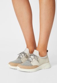 Lightweight sneakers featuring a mix of beige leather and gray felt, with textured accents, round toe, and lace-up design.
