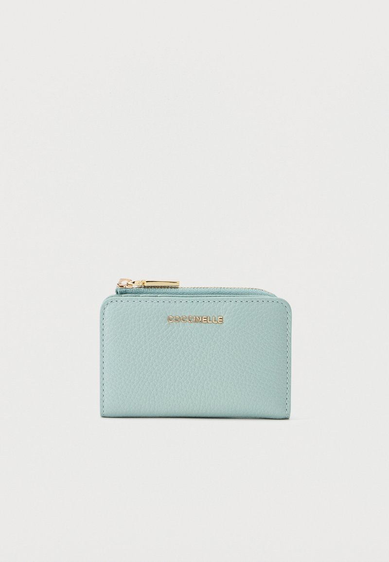 Πορτοφόλι από δερματίνη σε ανοιχτό μπλε χρώμα με υφή, με χρυστό φερμουάρ και λογότυπο COCCINELLE στο μπροστινό μέρος, ορθογώνιο συμπαγές σχέδιο.