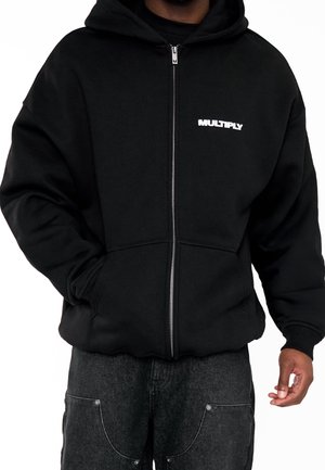 Felpa nera con zip in cotone morbido, con cappuccio ampio, tasche frontali e logo "MULTIPLY" bianco sul lato sinistro del petto.