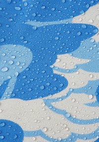 Blue and white fabric featuring a wave pattern, with drops of water beaded on the surface, reflecting a smooth texture.