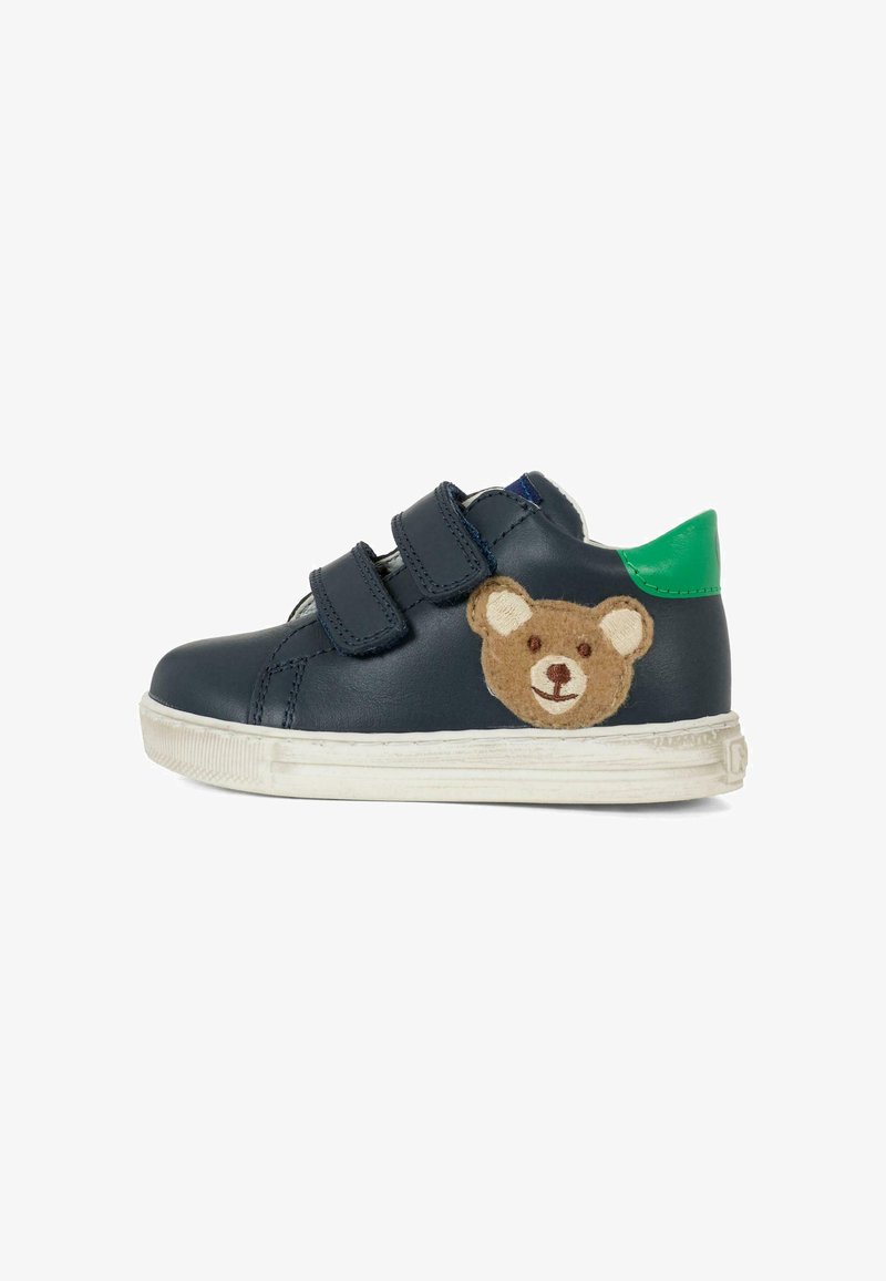 Sneaker in pelle color navy con due cinturini in Velcro neri. Presenta un'applicazione di un orsetto di peluche marrone sul lato e un accento verde sul tallone.