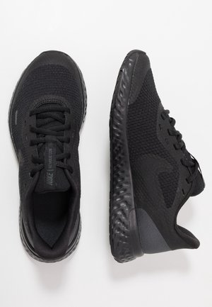 Musta urheilukengät, joissa on teksturoitu verkko-osa, pyöristetty kärki ja paksu, joustava kumipohja. Varusteena nauhat ja logo kielen kohdalla.