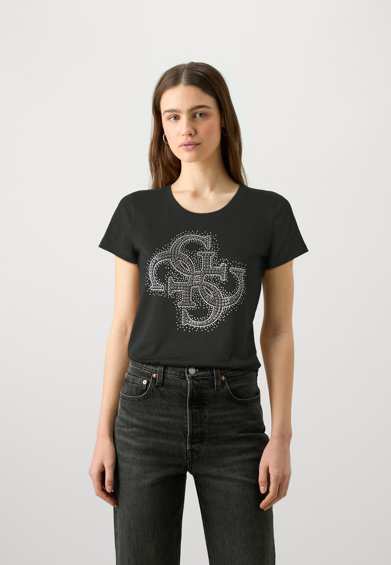 Camiseta de algodón negra con un diseño decorativo de pedrería, con cuello redondo y mangas cortas, combinada con jeans oscuros.