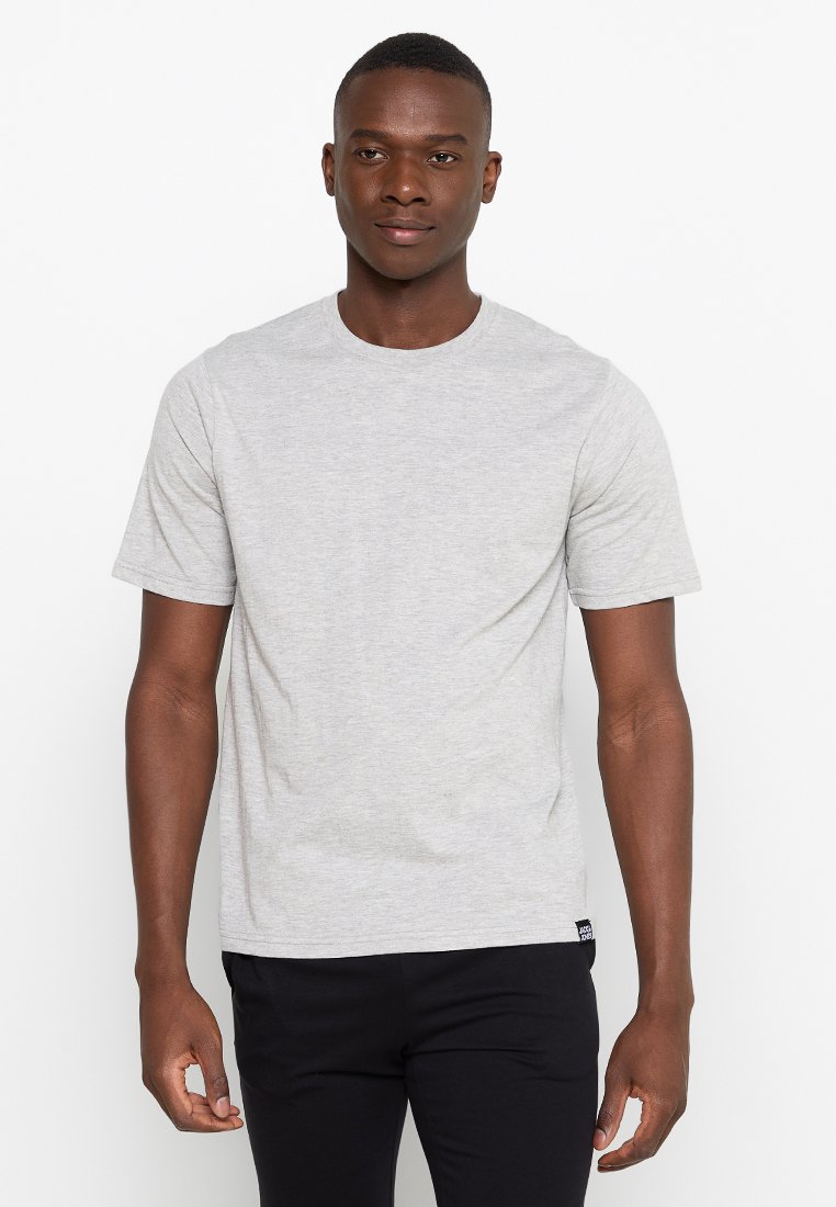 Camiseta gris de manga corta con cuello redondo. Tejido suave con una textura lisa. Detalle de etiqueta negra en el dobladillo.