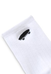 Vita bomullssocka med en svart skateboard-emblem broderad vid kanten. Ribbad textur, standard längd till mitt på vaden.