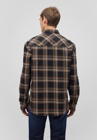 Schwarz-orangene kariert Hemd mit Button-Down-Kragen, langen Ärmeln und geradem Saum. Hergestellt aus einem gewebten Stoff mit einer weichen Textur.