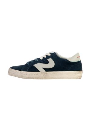Zapatillas de ante azul marino con acentos blancos, cordones beige y una suela de goma texturizada. Presentan un logo prominente en el costado.