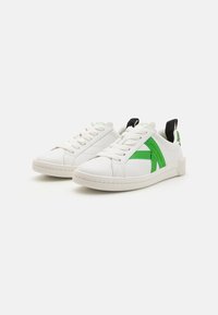 Sneaker bianche in pelle liscia con dettagli in tessuto verde, caratterizzate da punte rotonde, chiusura con lacci e suole in gomma testurizzata.