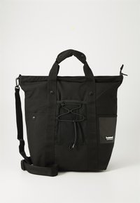 Črna torba iz trpežnega blaga, ki ima dva zgornja ročaja, naramnico, mrež pockets, podrobnosti z vrvico in stranski logotip.