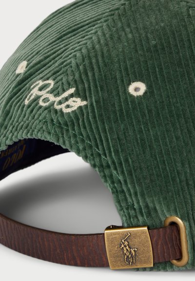 Căciulă din corduroy verde, cu logo-ul brodat "Polo" și două gromete pentru ventilație. Curea din piele maro cu cataramă din alamă și detalii cu logo.