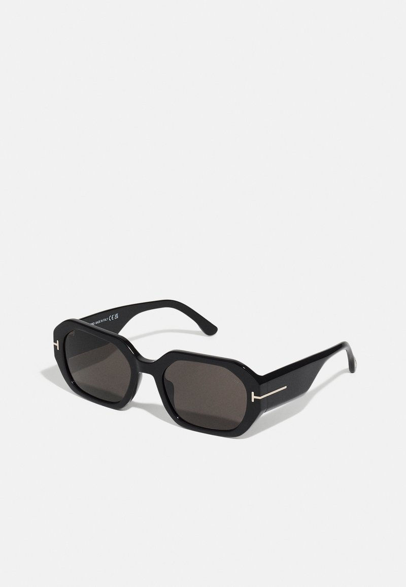 Ochelari de soare octogonali negri cu lentile întunecate. Dispun de un cadru elegant și lucios. Accente subțiri de aur pe partea din față și pe laturi îmbunătățesc designul.