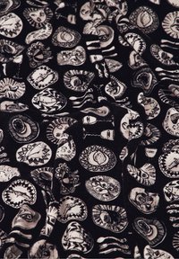 Schwarzer Stoff mit weißen illustrierten Motiven, darunter Gesichter, Objekte und Muster. Das Design weist unterschiedliche Formen und komplexe Details auf.