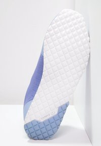 Fialové síťované tenisky s texturovanou bílou a světle modrou gumovou podrážkou. Obsahují diamantový vzor na podrážce pro lepší přilnavost.