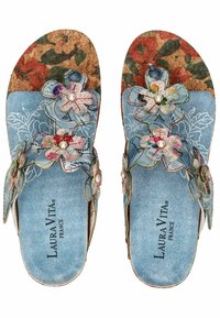 Sandales en liège avec un motif floral bleu, ornées de fleurs en tissu et de perles, dotées d'une semelle intérieure texturée et d'un logo imprimé sur la semelle.