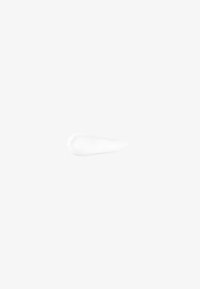 Biały połyskujący krem rozmazany z zaokrągloną podstawą i zwężającym się końcem na jasnoszarym tle.