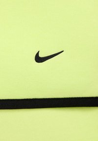 Tela deportiva de color amarillo brillante con un logo negro de Nike. Presenta una banda negra en contraste a lo largo del borde inferior, con superficie texturada.