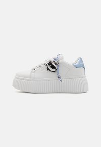 Vita lädersneakers med en tjock, ribbad vit sula. Har blå detaljer och en svart charm fäst vid snöret. Rund tådesign.