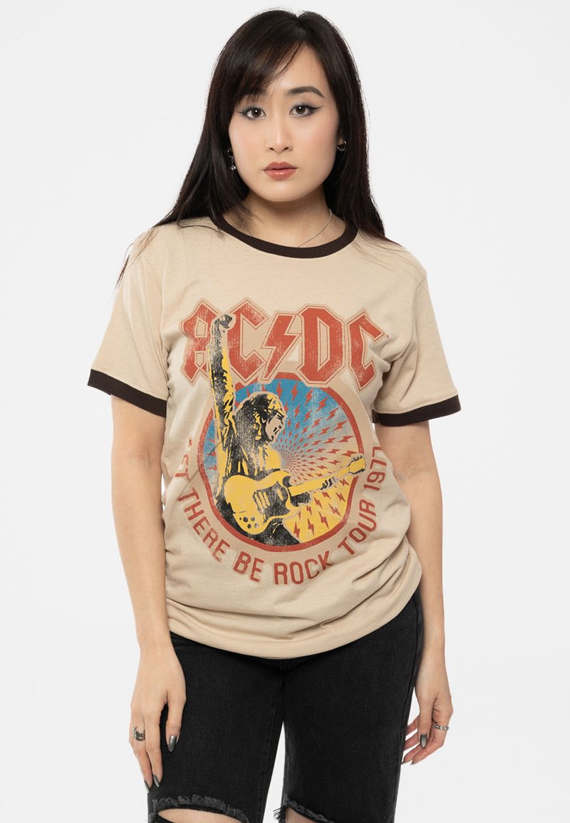 Cotton beige t-shirt with brown ribbed collar, featuring a graphic of a guitarist and text "AC/DC Let There Be Rock Tour 1977."