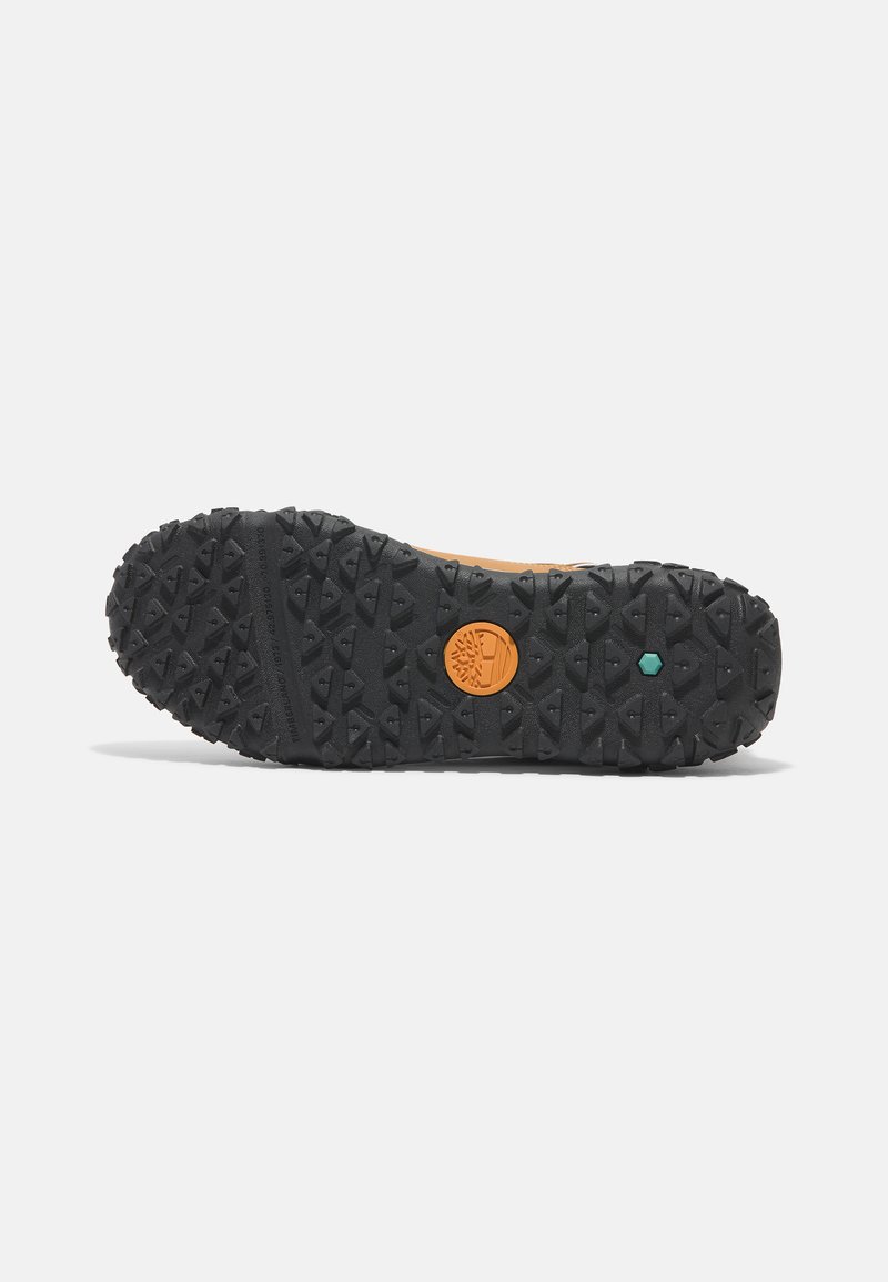 Rubberen buitenzool met diepe profielen voor grip, met een oranje logo en een groene accenten. Zwarte kleur met gestructureerde patronen voor extra grip.