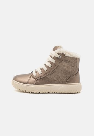 Zapatilla alta marrón hecha de materiales metálicos y texturizados, con un cuello forrado de piel, cordones blancos y una suela gruesa beige.