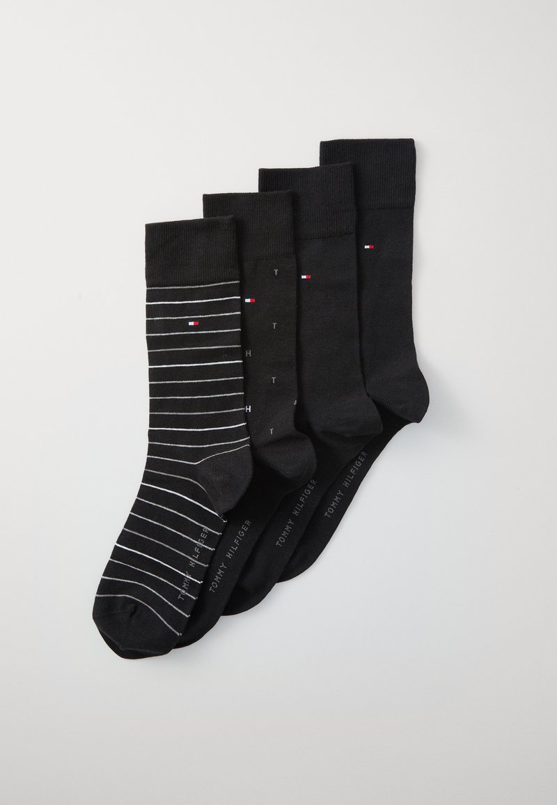 Conjunto de calcetines negros que incluye cuatro pares: uno con rayas blancas y los otros lisos. Cada par tiene un puño acanalado y texto de marca. Material de mezcla de algodón.