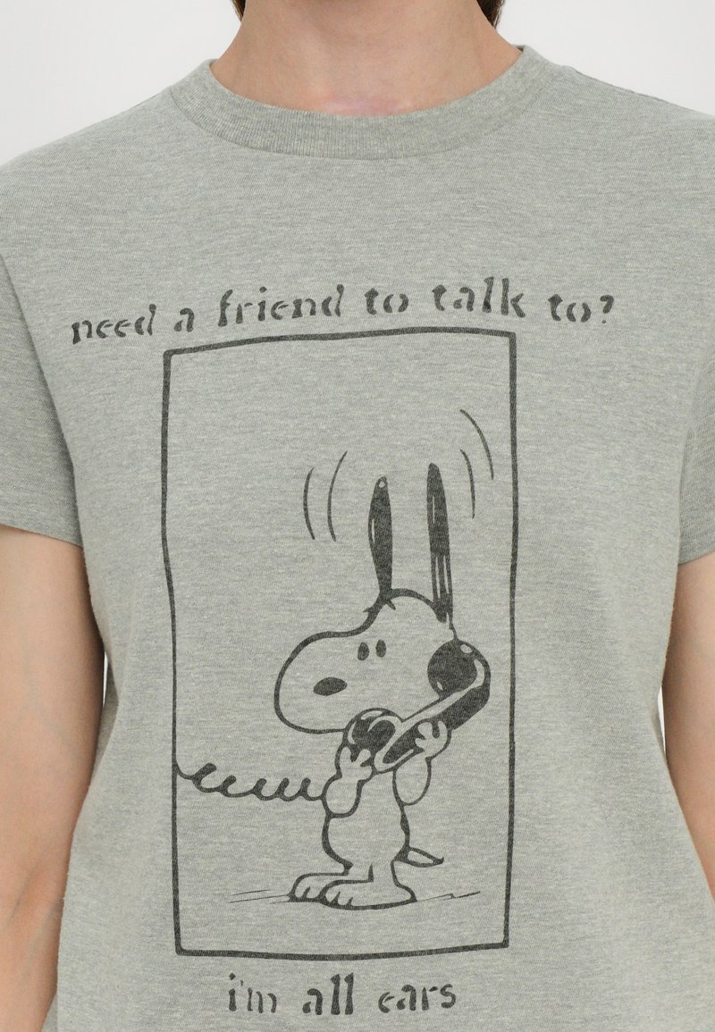 Heather gray t-shirt featuring a cartoon dog holding a phone, bordered by a rectangle with the text "need a friend to talk to?" above and "i'm all ears" below.