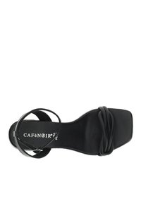 Sandal con tacco alto nero caratterizzato da una punta quadrata, design a strappo attorcigliato e una sottile cinghia alla caviglia. Texture liscia con un branding delicato sulla soletta.