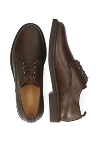 Zapatos de cuero marrón con punta redondeada, diseño de cierre con seis ojales y tacón plano. Textura suave, detalles sutiles de costura y suela sólida.