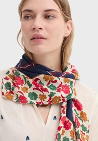 Écharpe à motif floral avec des fleurs rouges, vertes et moutarde sur un fond crème. Bordure bleu marine avec couture rouge. Tissu léger.