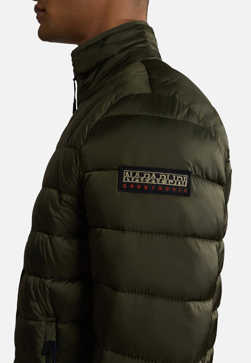 Oliwkowa kurtka puchowa z wysokim kołnierzem, pikowanym wzorem i zamkiem błyskawicznym z boku. Posiada materiałową naszywkę z logo na lewym ramieniu.