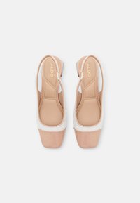 Decolletè slingback open-toe con una base pesca lucida, upper in bianco testurizzato e soletta imbottita, con un tacco a blocco modesto.