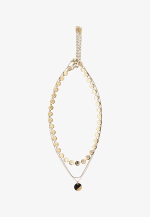 Kultasävyinen kerroksittain oleva kaulakoru, jossa yhdellä ketjulla pyöreitä hymyileviä kasvojen riipuksia ja ohuella ketjulla yksinkertainen pyöreä riipus.